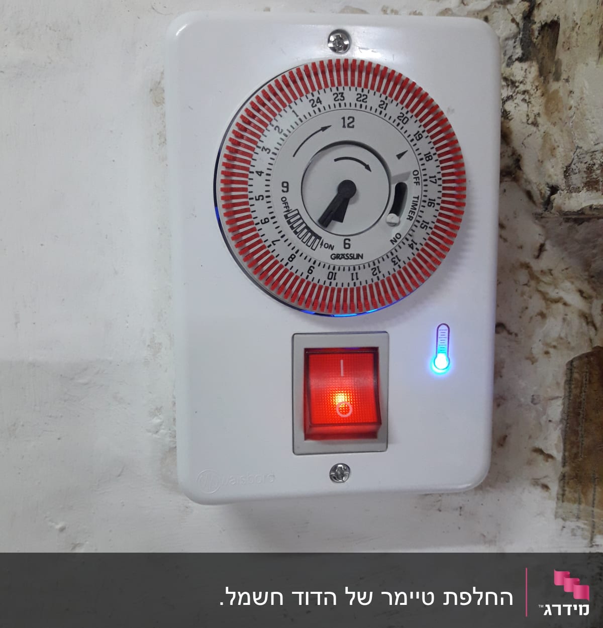 טיימר חשמלי עם מתג מואר על קיר